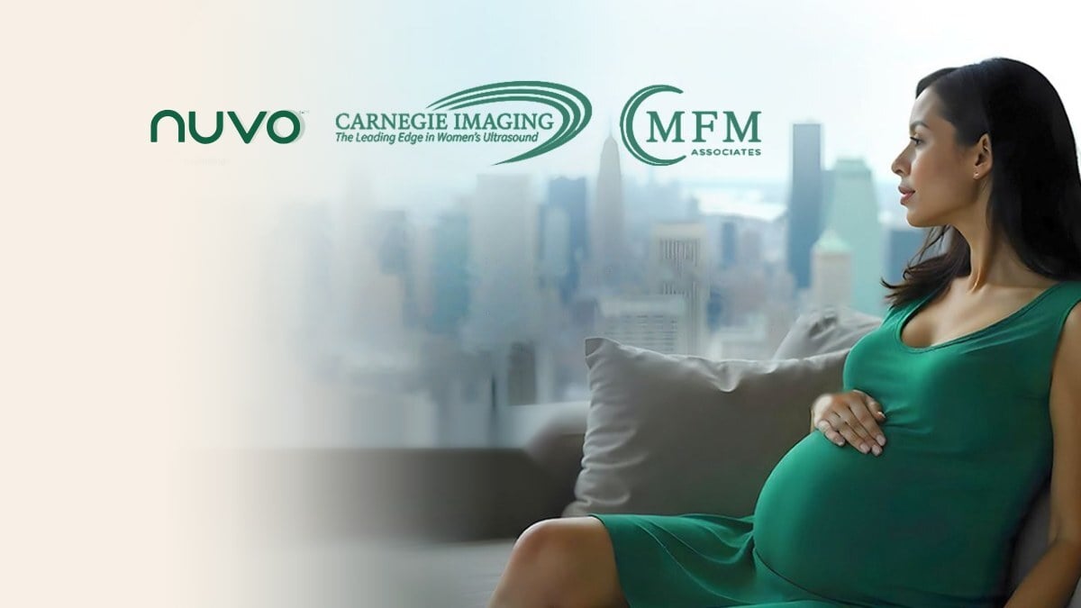 Expectant mother in a green dress by a window over the New York skyline, with the Nuvo, Carnegie Imaging and MFM Associates logos