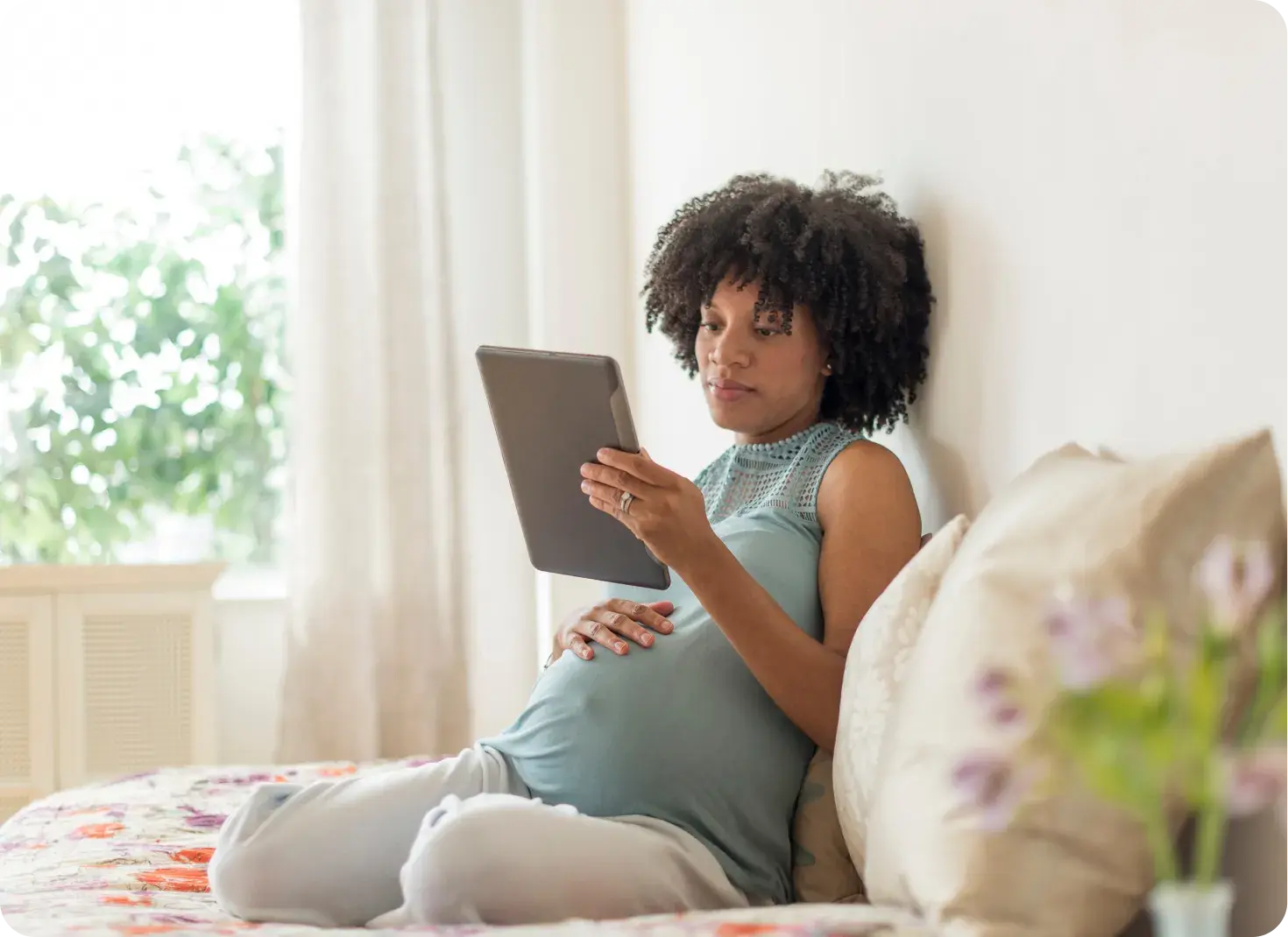 Expectant mother at home with a tablet